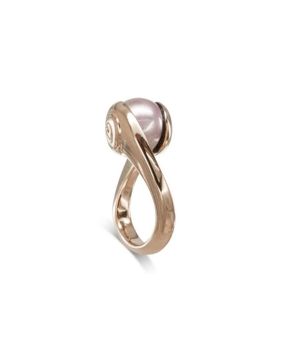 Rose gold ring with a suspended pink pearl in a modern, organic twisted band design