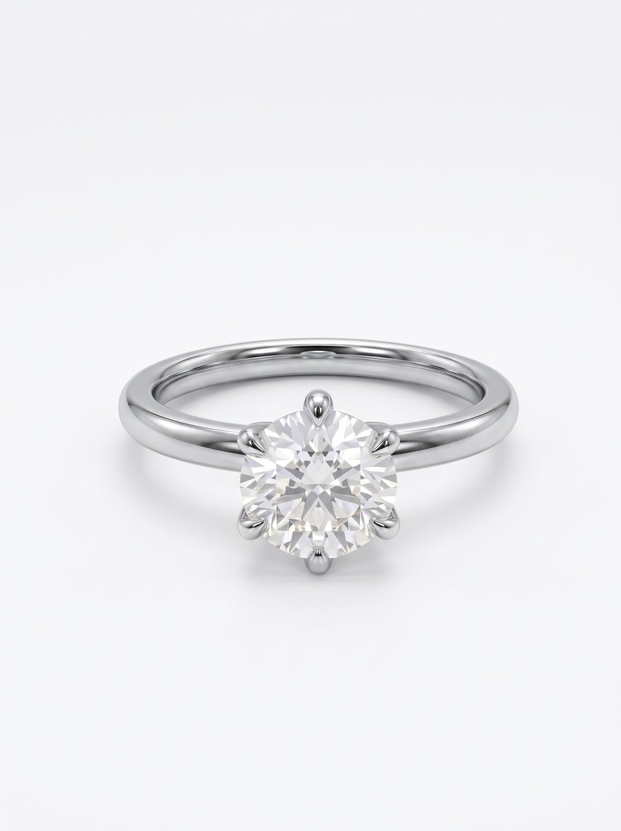 Round cut solitaire diamond engagement ring set in a polished silver-tone band with a six-prong setting.