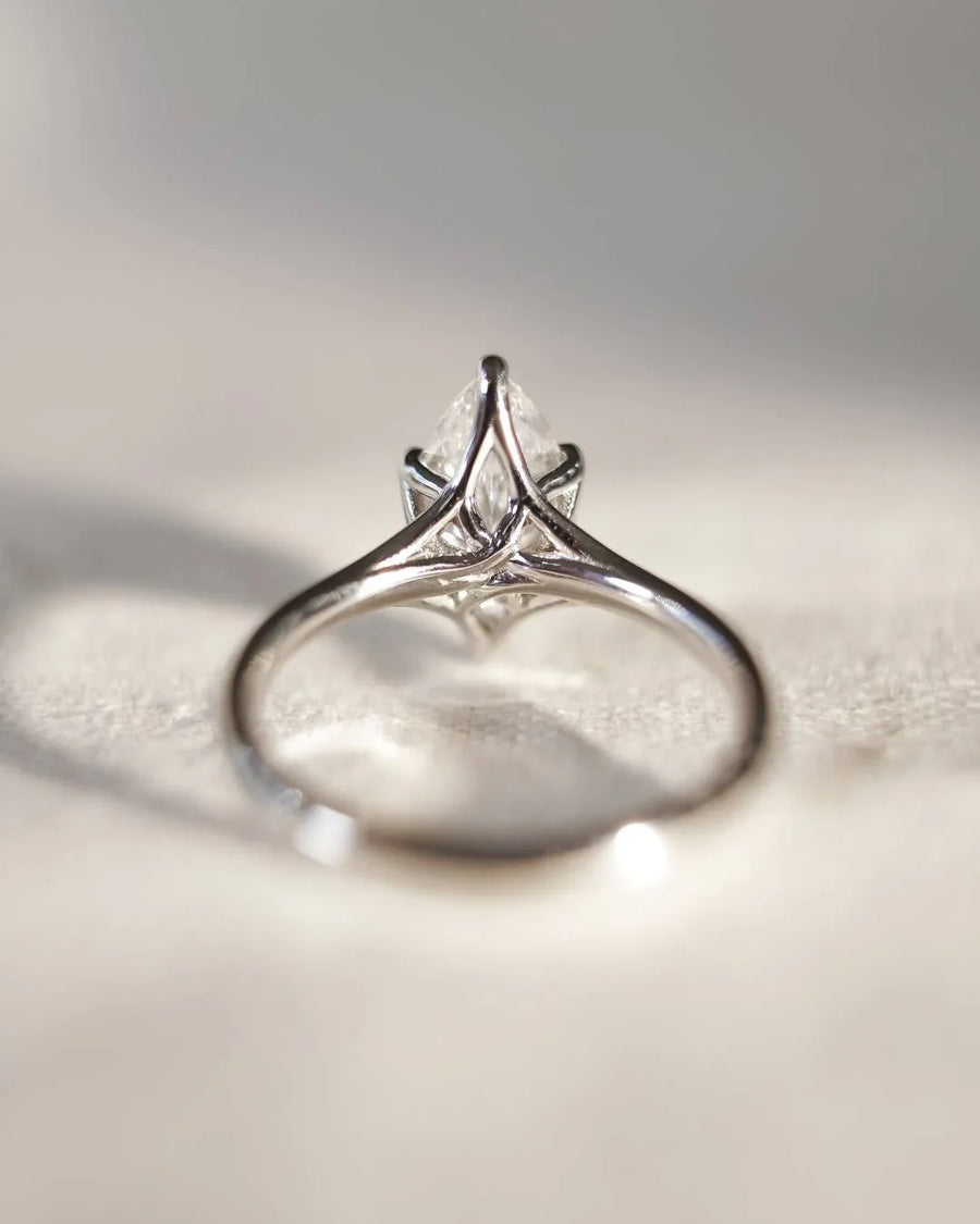 Platinum engagement ring with a marquise cut lab-grown diamond in a tulip setting.
