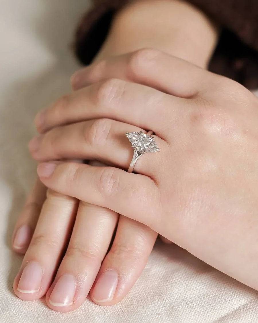 Platinum tulip engagement ring with a marquise cut lab-grown diamond on a hand.