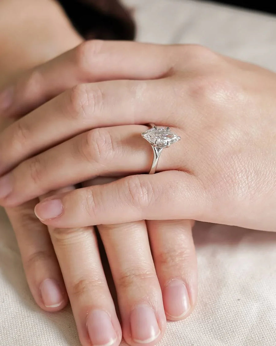 Platinum marquise cut lab-grown diamond tulip engagement ring on a hand.
