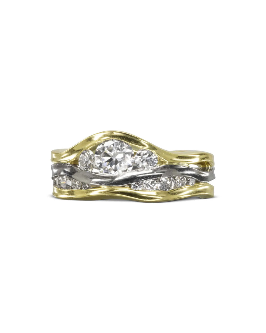 Gold and white gold three-band ring with a large center diamond and smaller diamonds.