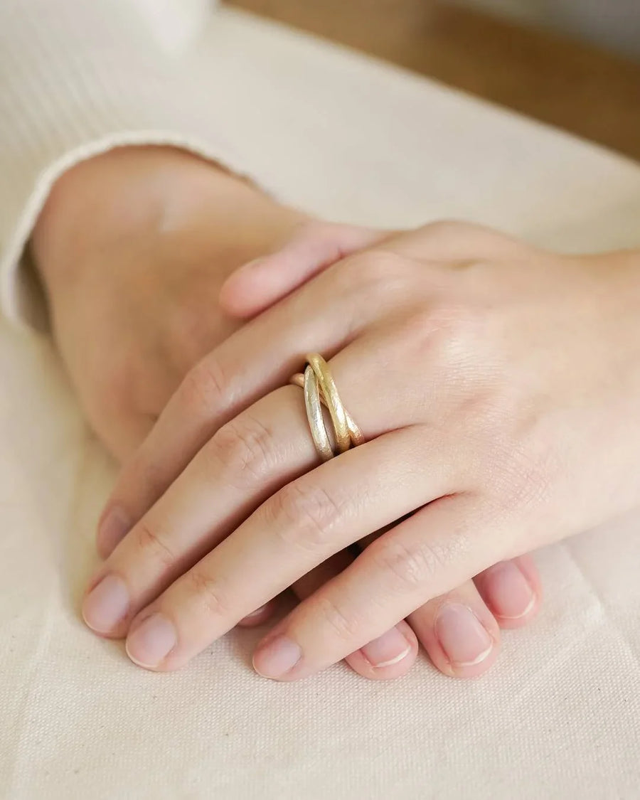 Handmade Russian ring with interlocking gold bands on a woman's hand, luxury jewellery