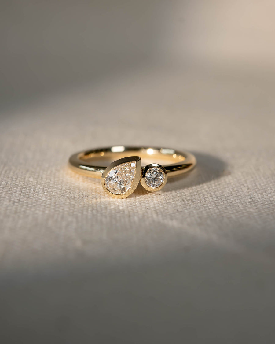 9ct yellow gold toi et moi engagement ring with a bezel-set pear and round lab grown diamond.