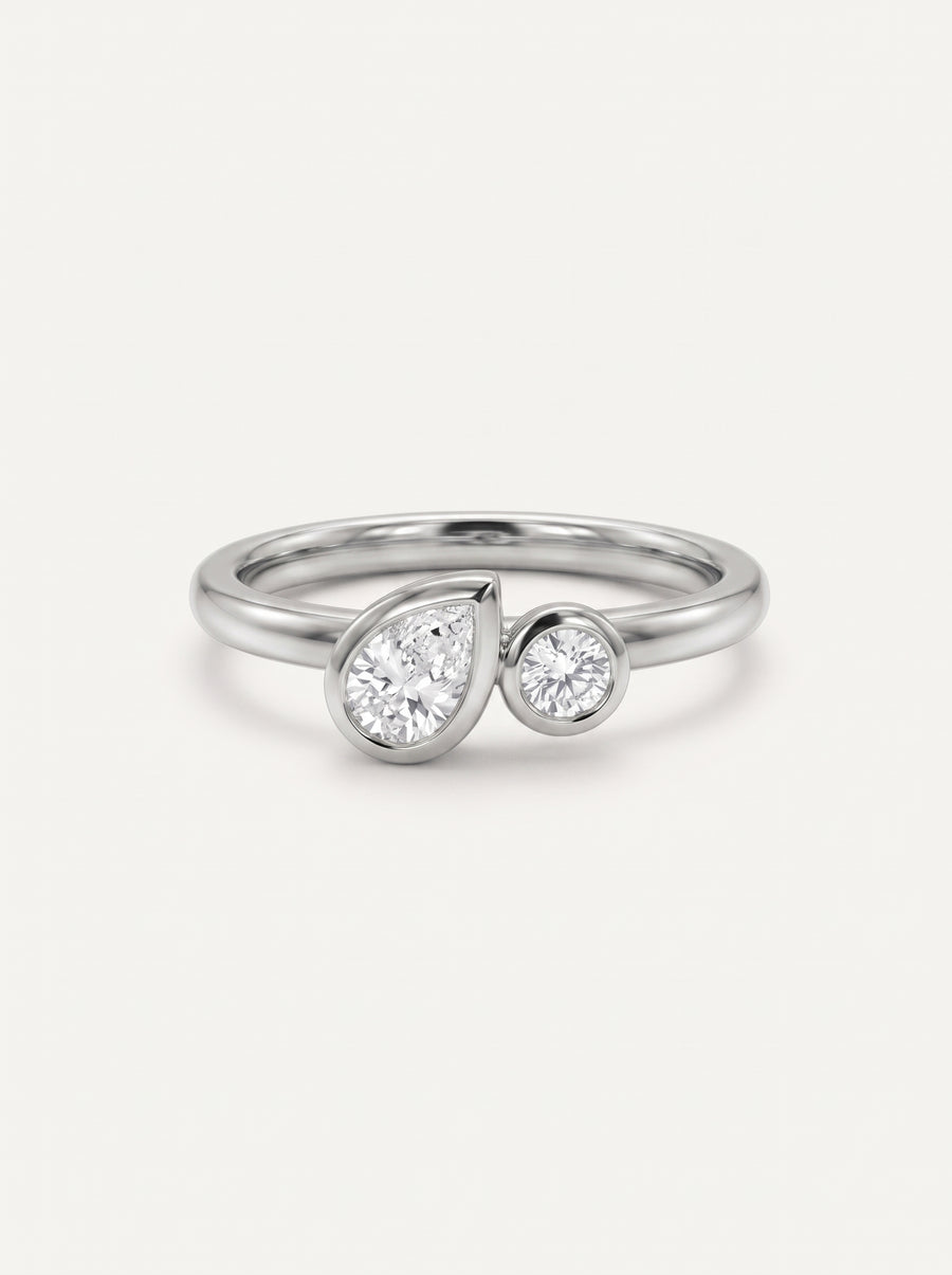 Platinum toi et moi engagement ring with bezel-set pear and round lab grown diamonds.