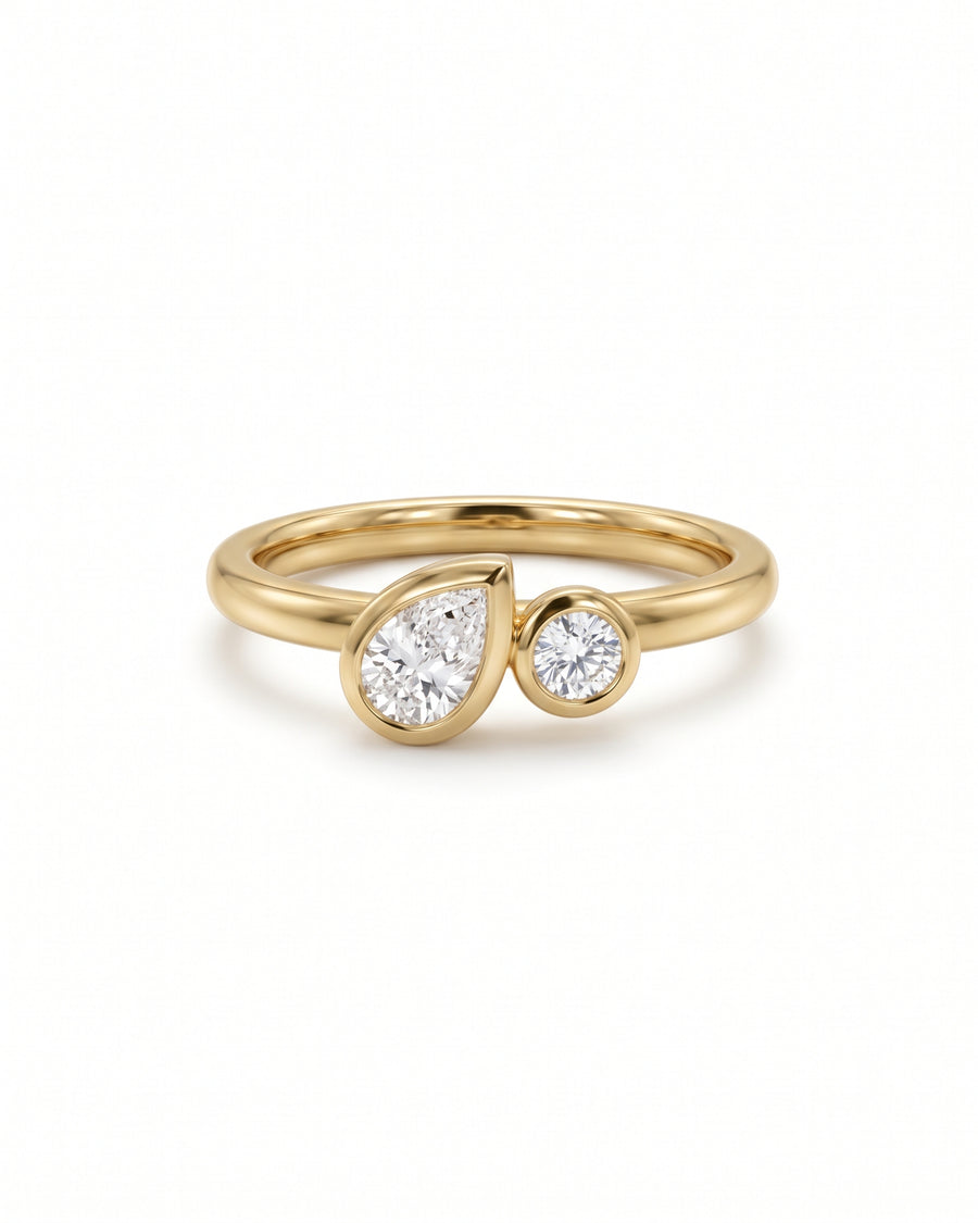 Toi et moi engagement ring in 9ct yellow gold with a bezel-set pear and round lab grown diamond.