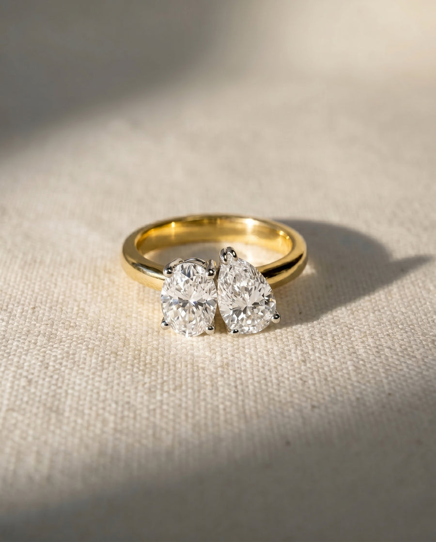 Yellow gold ring with oval and pear-shaped diamonds.