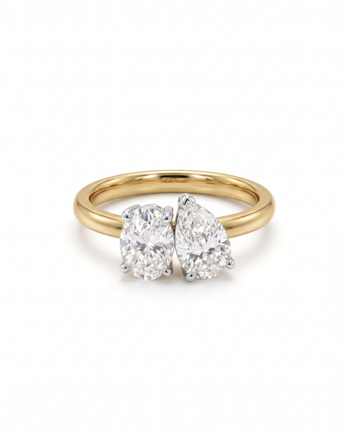 Gold toi et moi ring featuring an oval and a pear-cut diamond in claw settings.