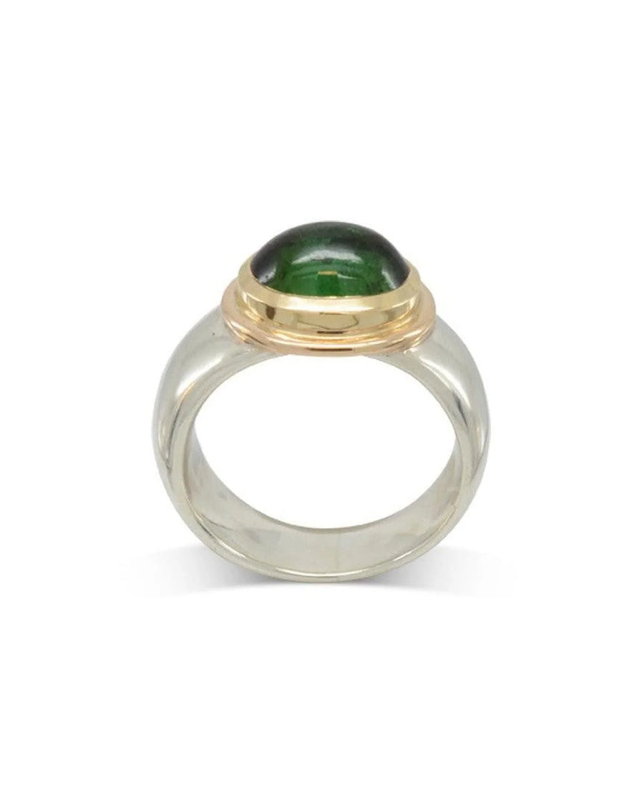 Green tourmaline cabochon ring in a gold bezel setting with a wide silver band.