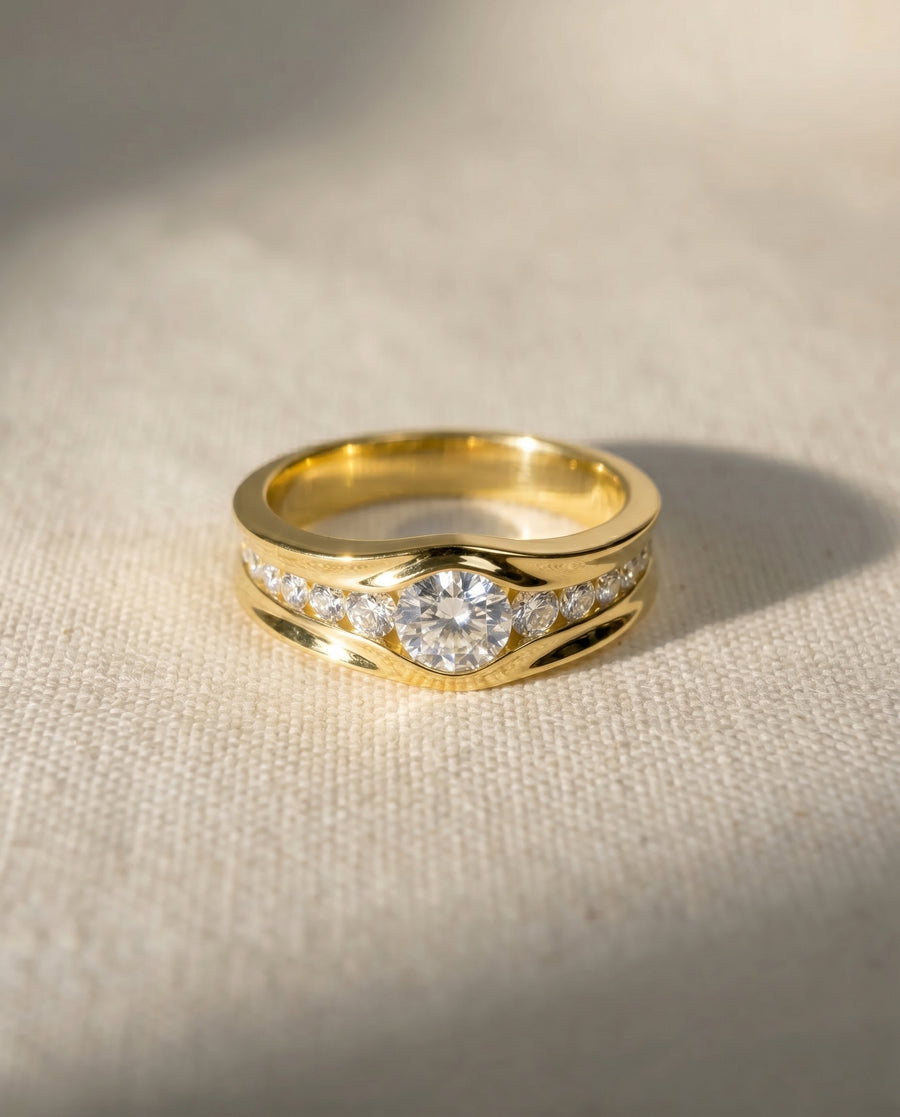 18ct yellow gold engagement ring with a central round diamond and smaller diamonds on either side.