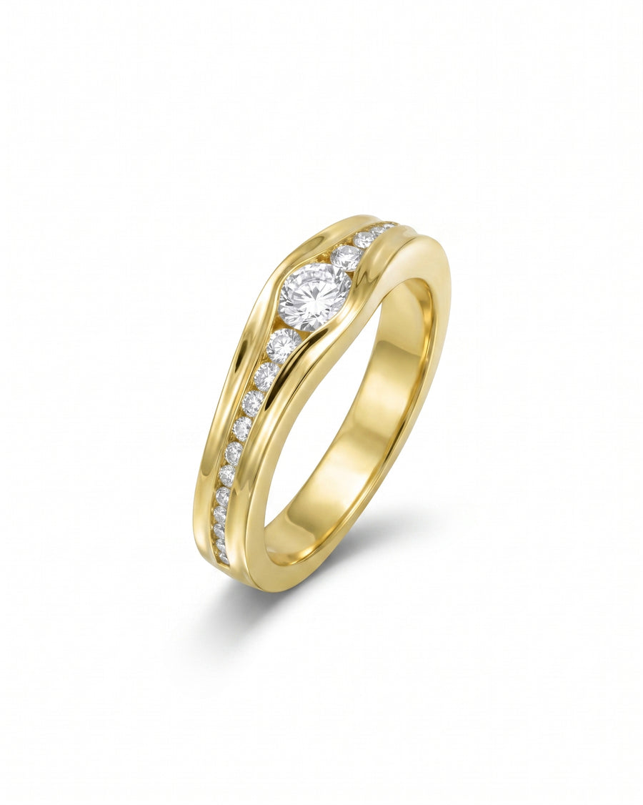 Gold engagement ring with a central round diamond and channel-set diamonds.