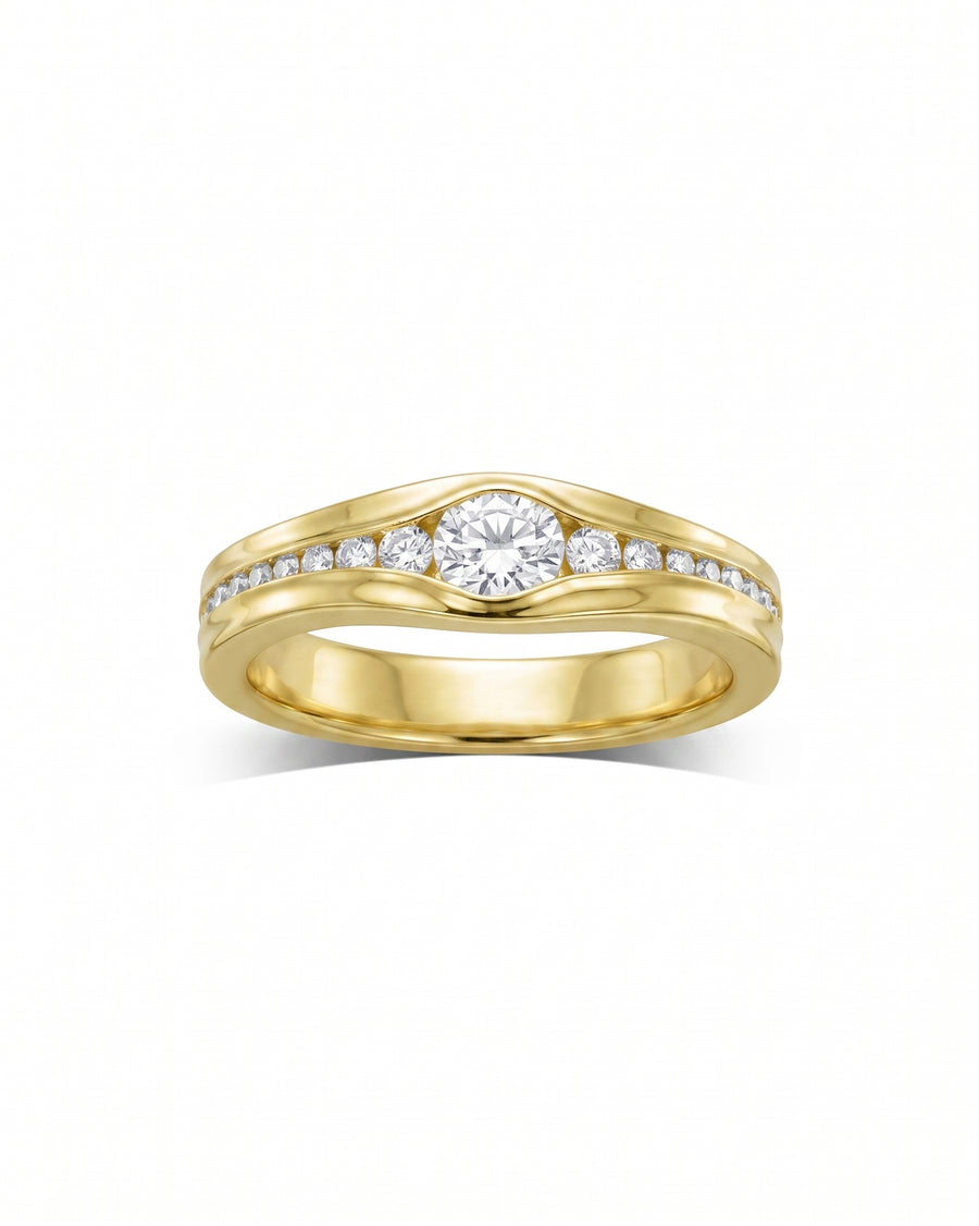 Yellow gold engagement ring with a central round diamond and channel-set side diamonds.