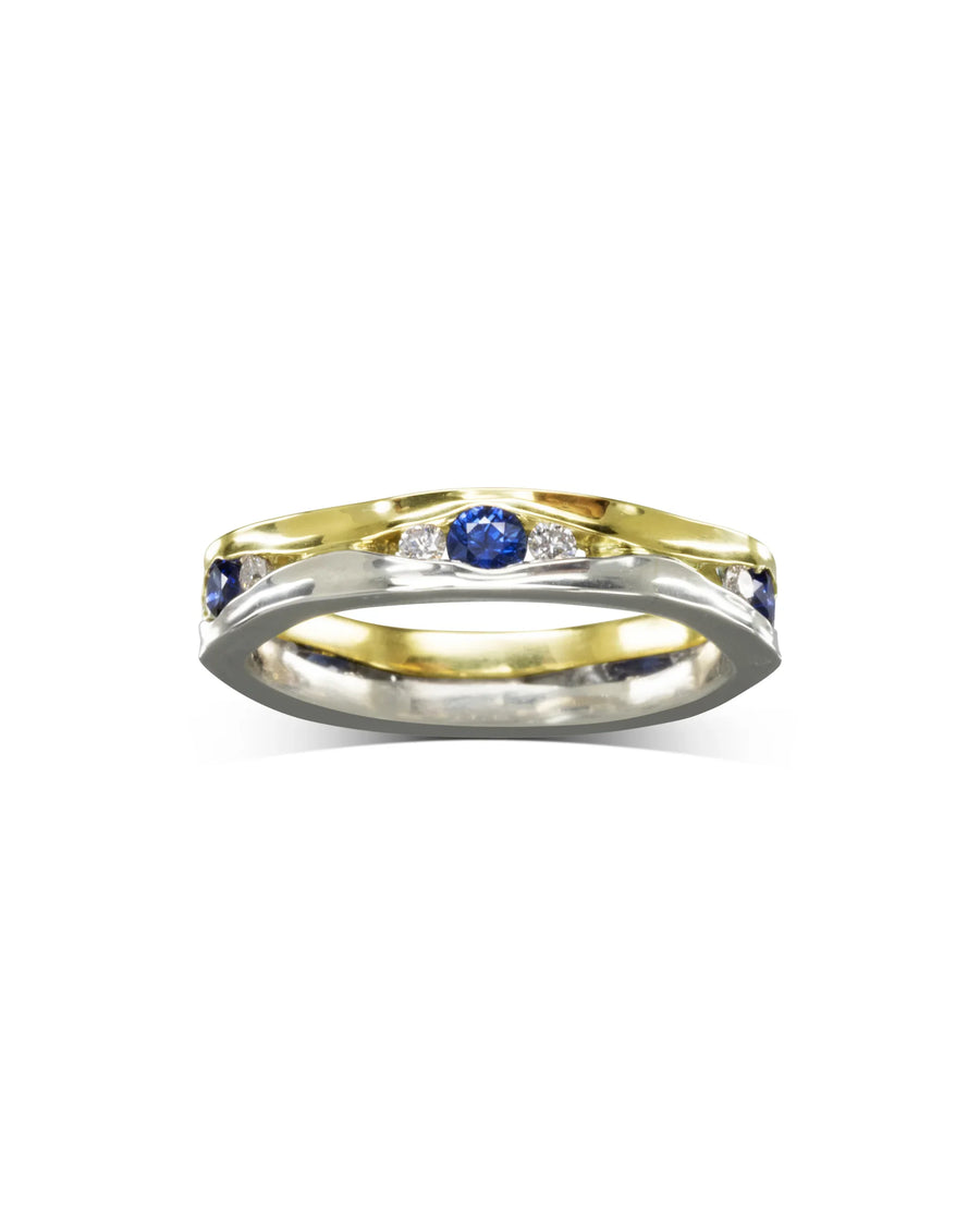 Gold and silver eternity ring with blue sapphires and diamonds.