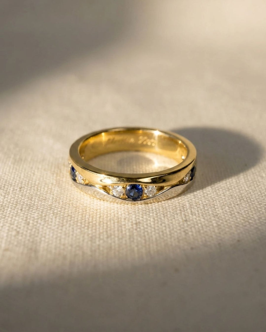 Yellow and white gold eternity ring with blue sapphires and diamonds.