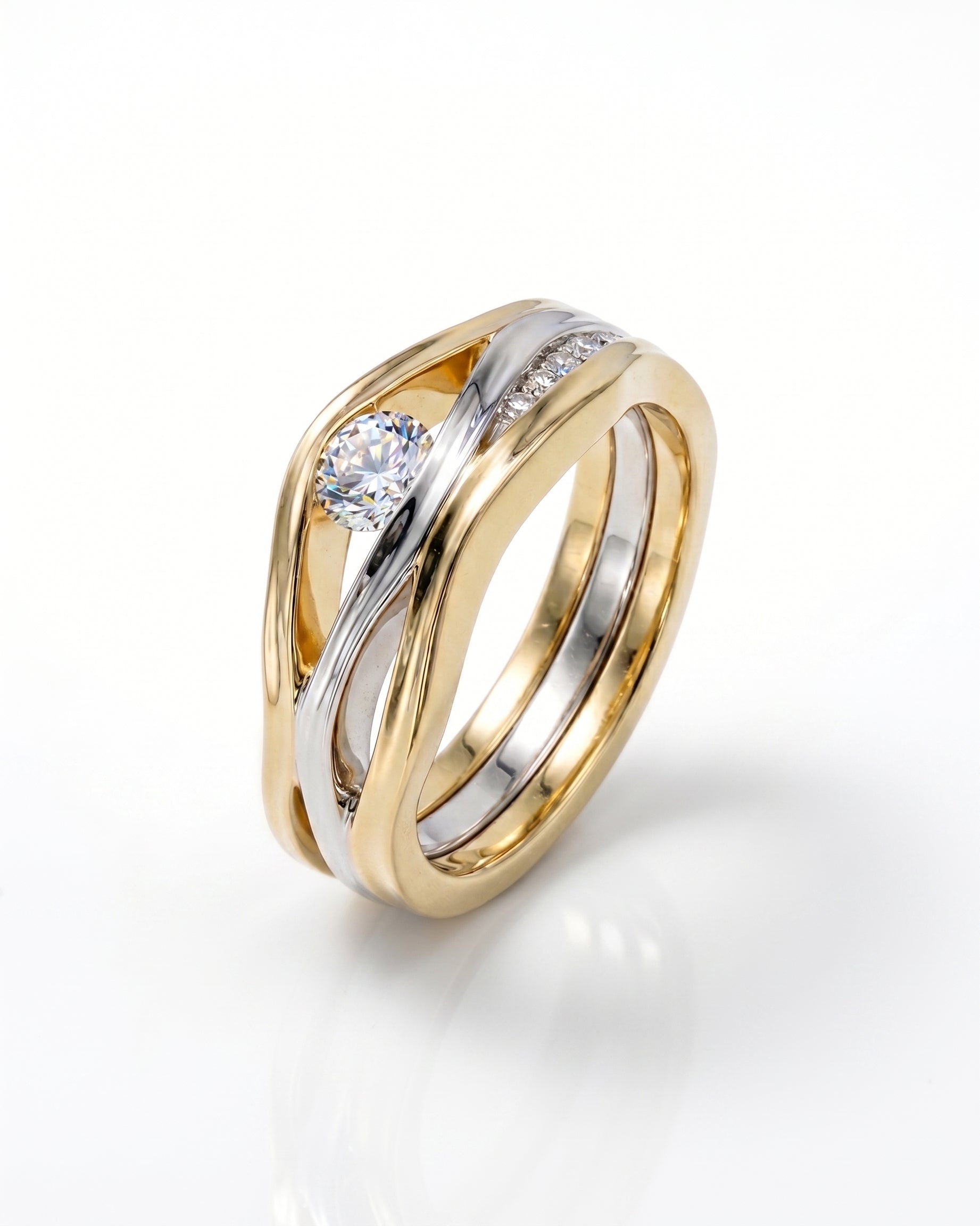 Gold and silver three-band diamond ring with a round center stone and pave diamonds.