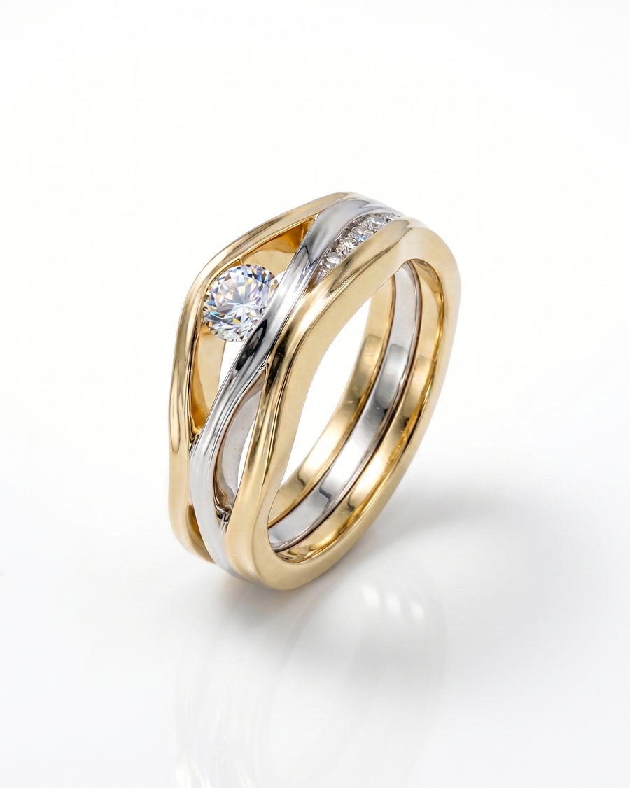 Gold and silver three-band diamond ring with a round center stone and pave diamonds.