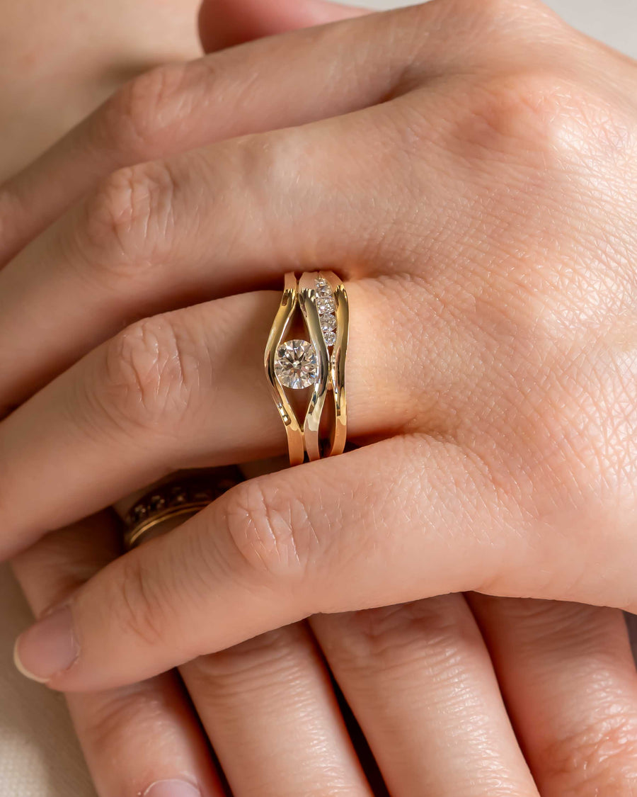 Gold three band ring with a large center diamond and smaller accent diamonds.