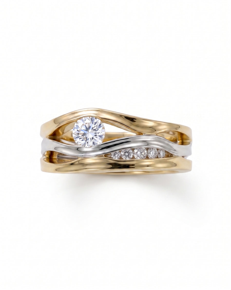 Gold and silver three-band ring with a round diamond and smaller accent diamonds.