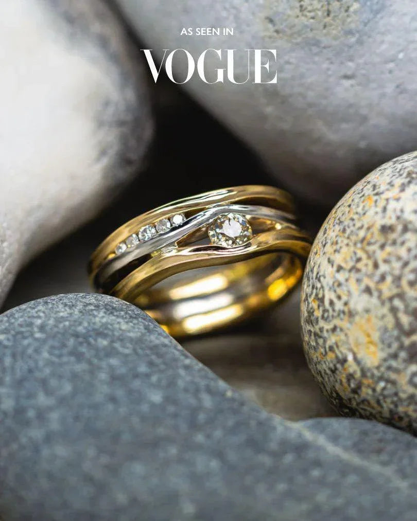 Gold and silver three-band ring with a central diamond and smaller accent diamonds.