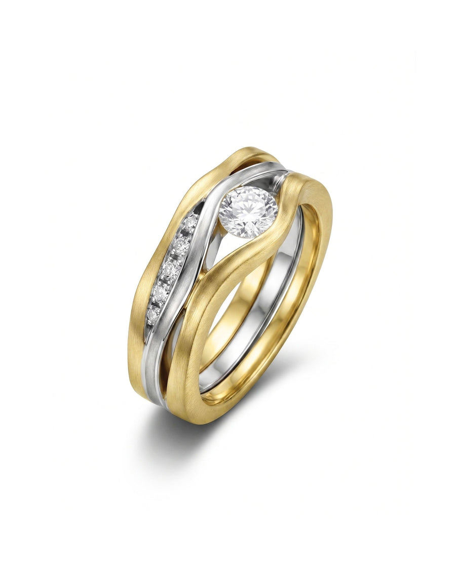 Satin finish three-band gold and silver ring with a large diamond and smaller accent diamonds.
