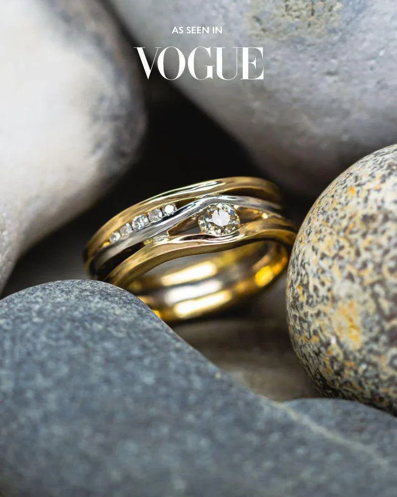 Gold and silver three-band ring with a central diamond and accent diamonds, satin finish.