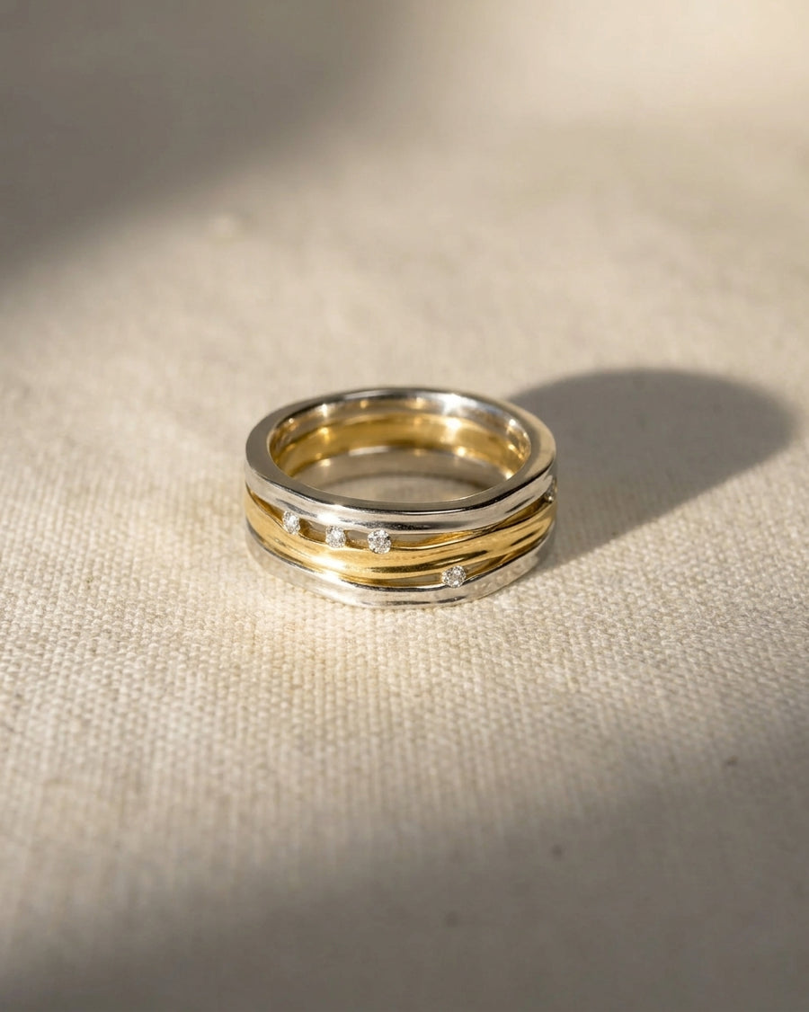 Three-band organic eternity ring in silver and gold with small inset diamonds.