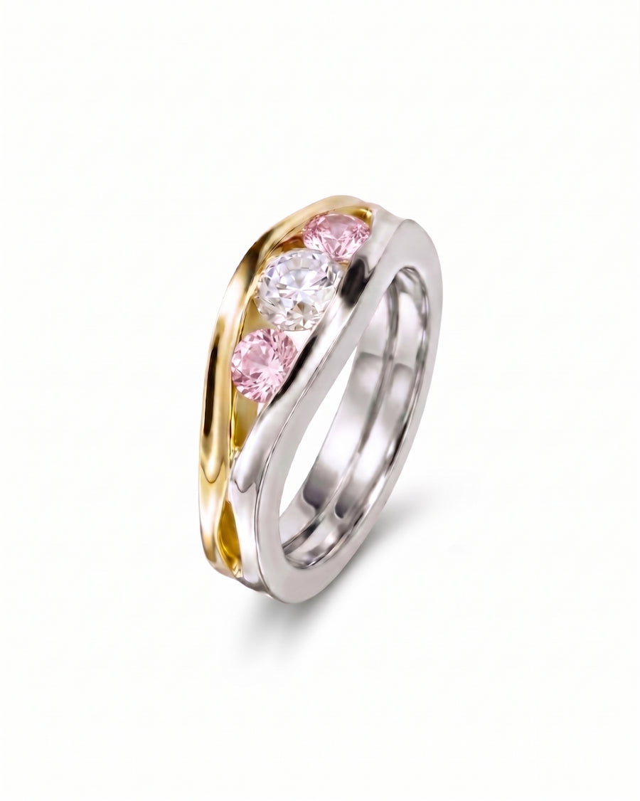 Gold and silver engagement ring with three round pink and white gemstones.