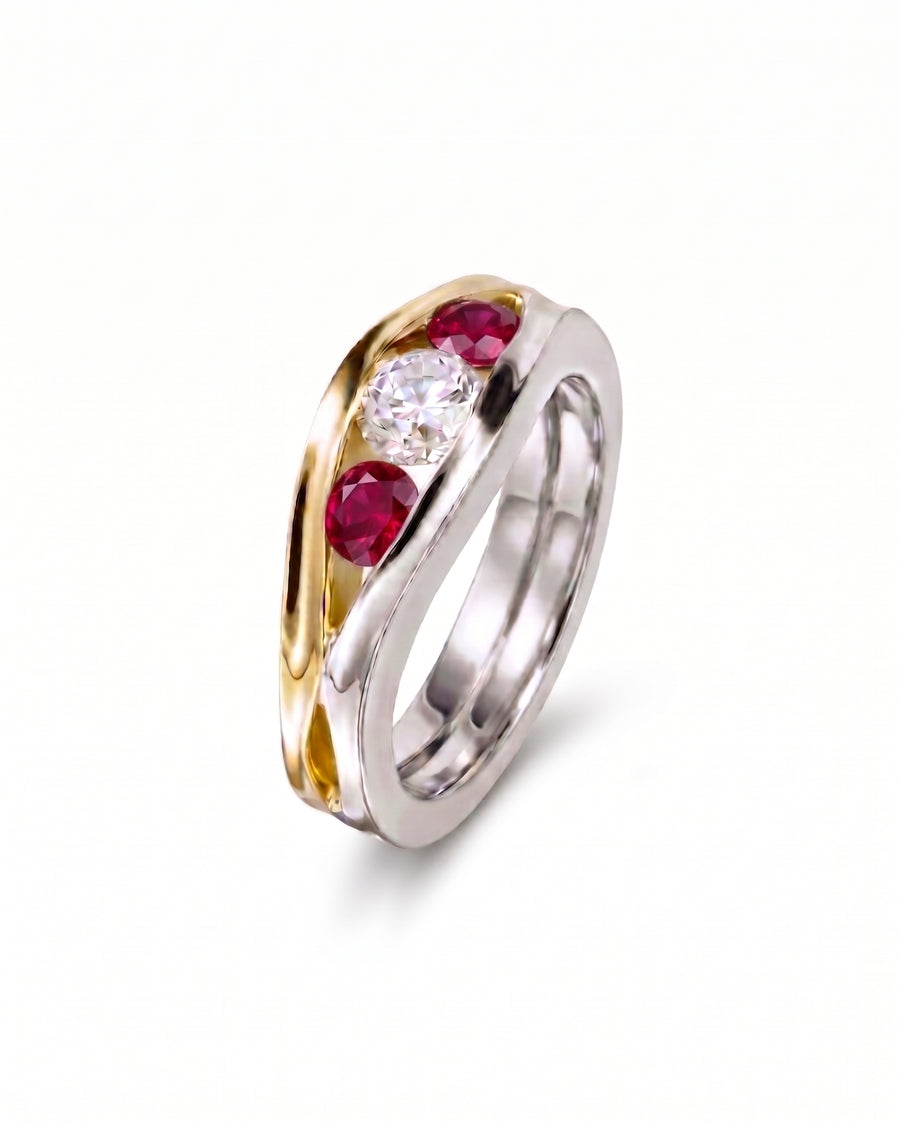 Gold and silver ring with three gemstones: one diamond and two rubies.