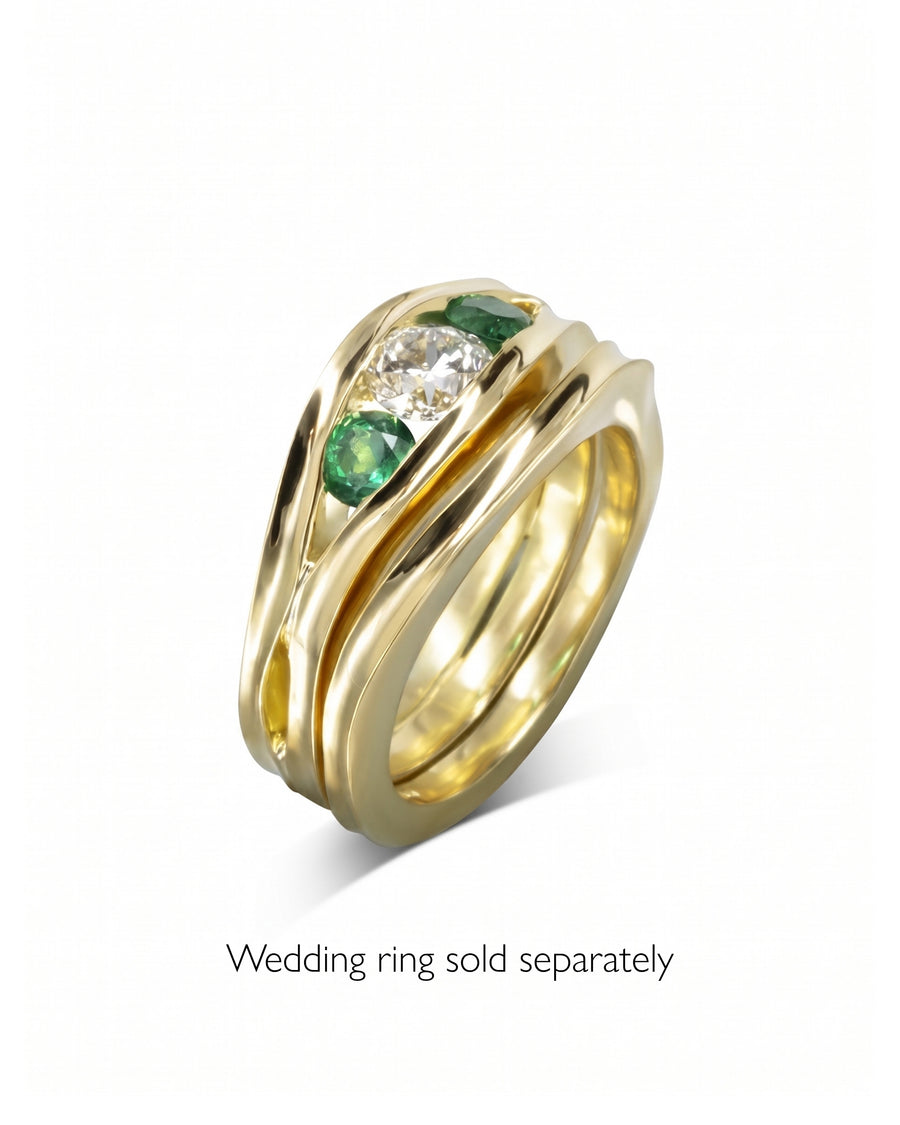 Gold ring with a central diamond and two emerald gemstones.