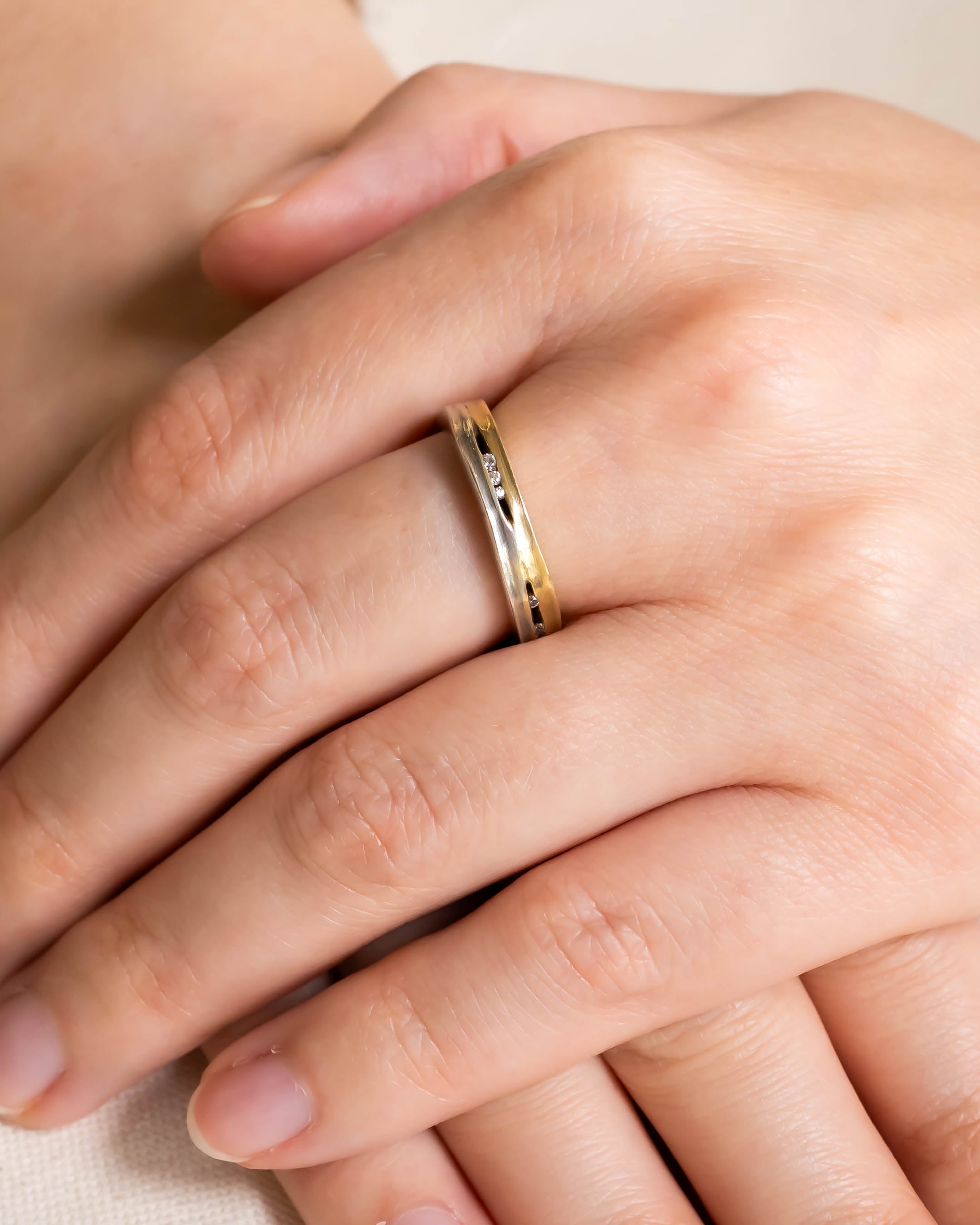Two-colour gold ring with three small diamonds.