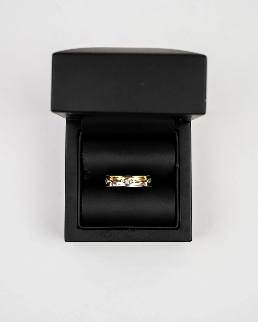 Two-colour gold diamond ring in a black box.