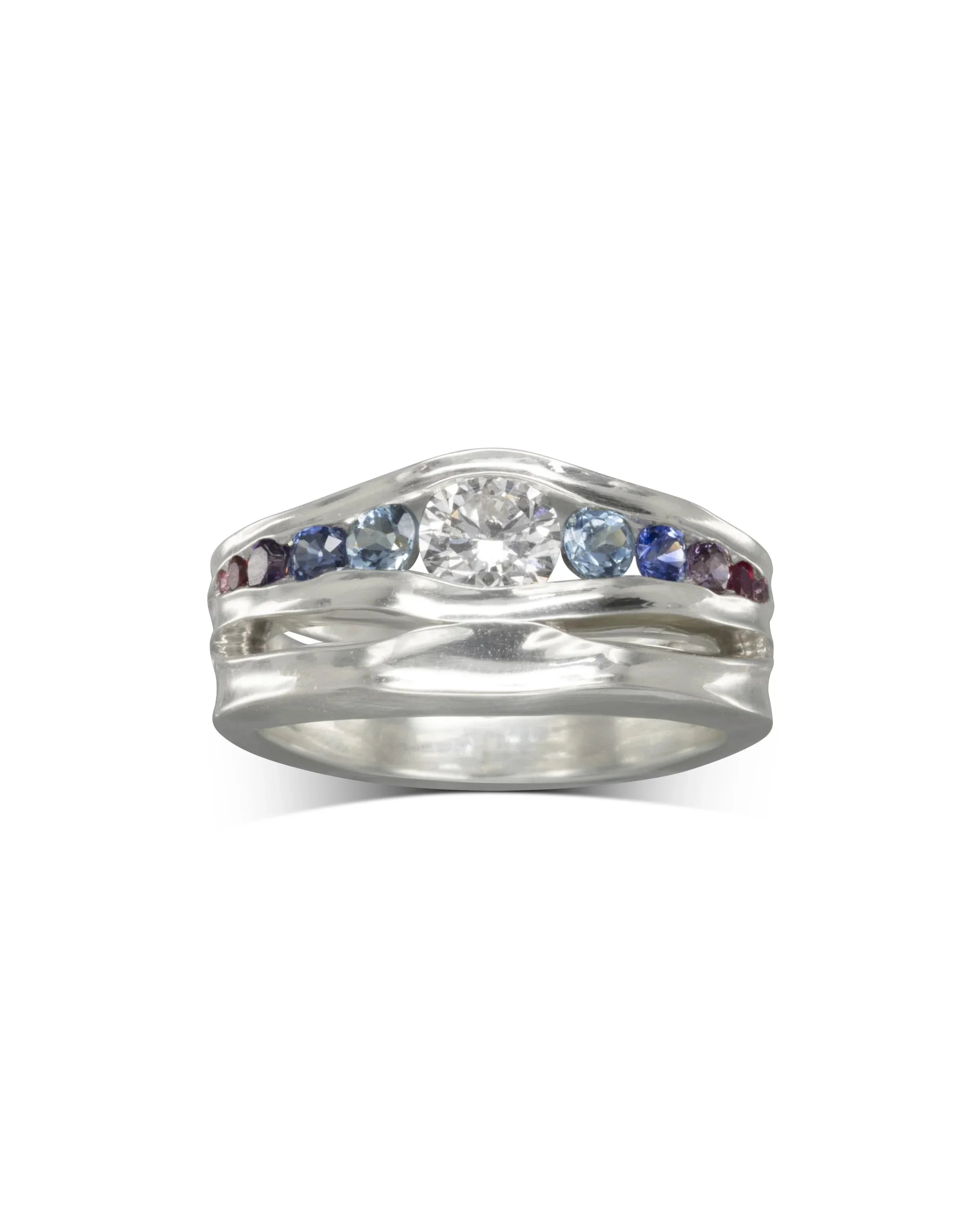 Handcrafted silver engagement ring with graduated sapphires and a central diamond