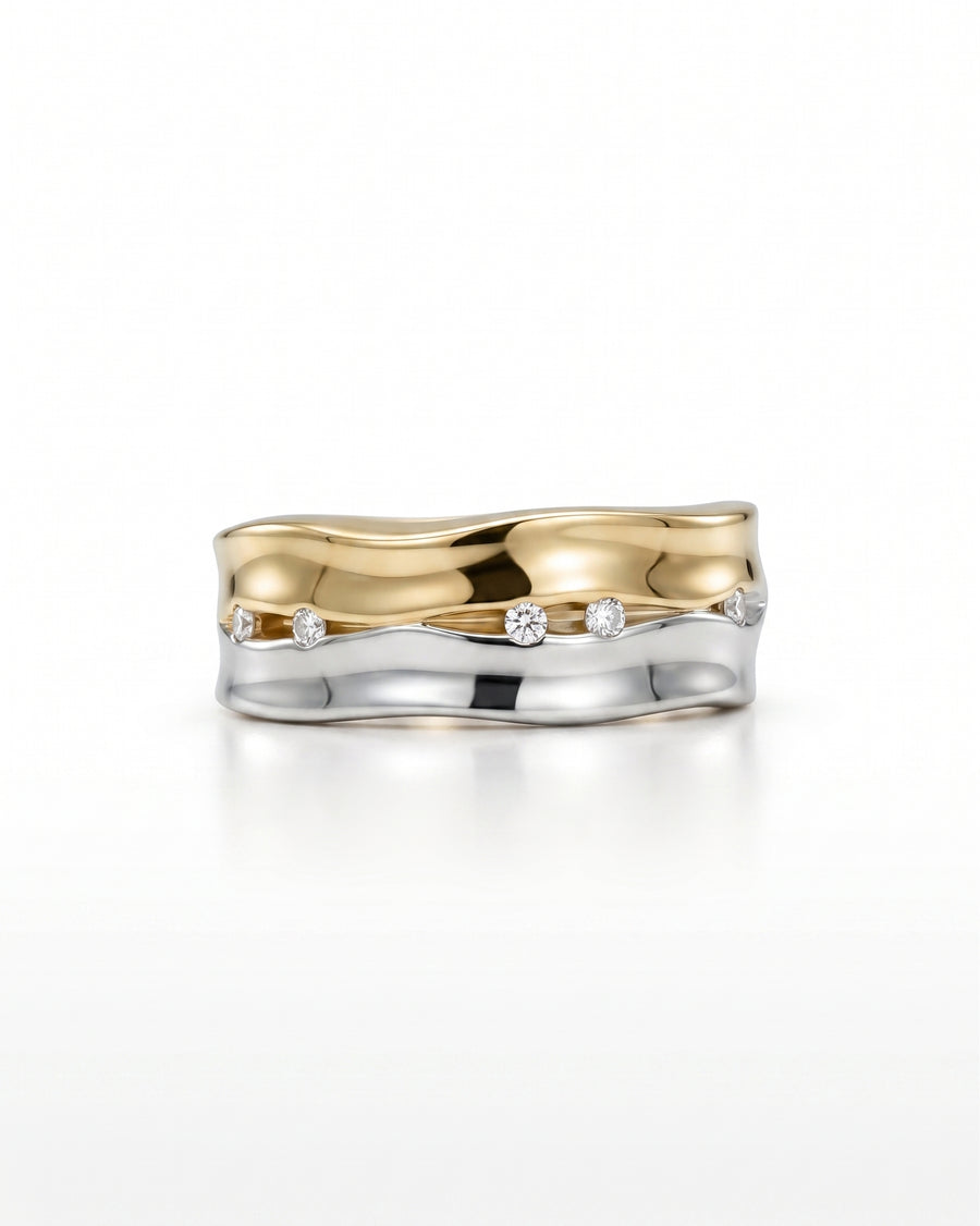 Wide two-colour gold and silver eternity ring with scattered diamonds.