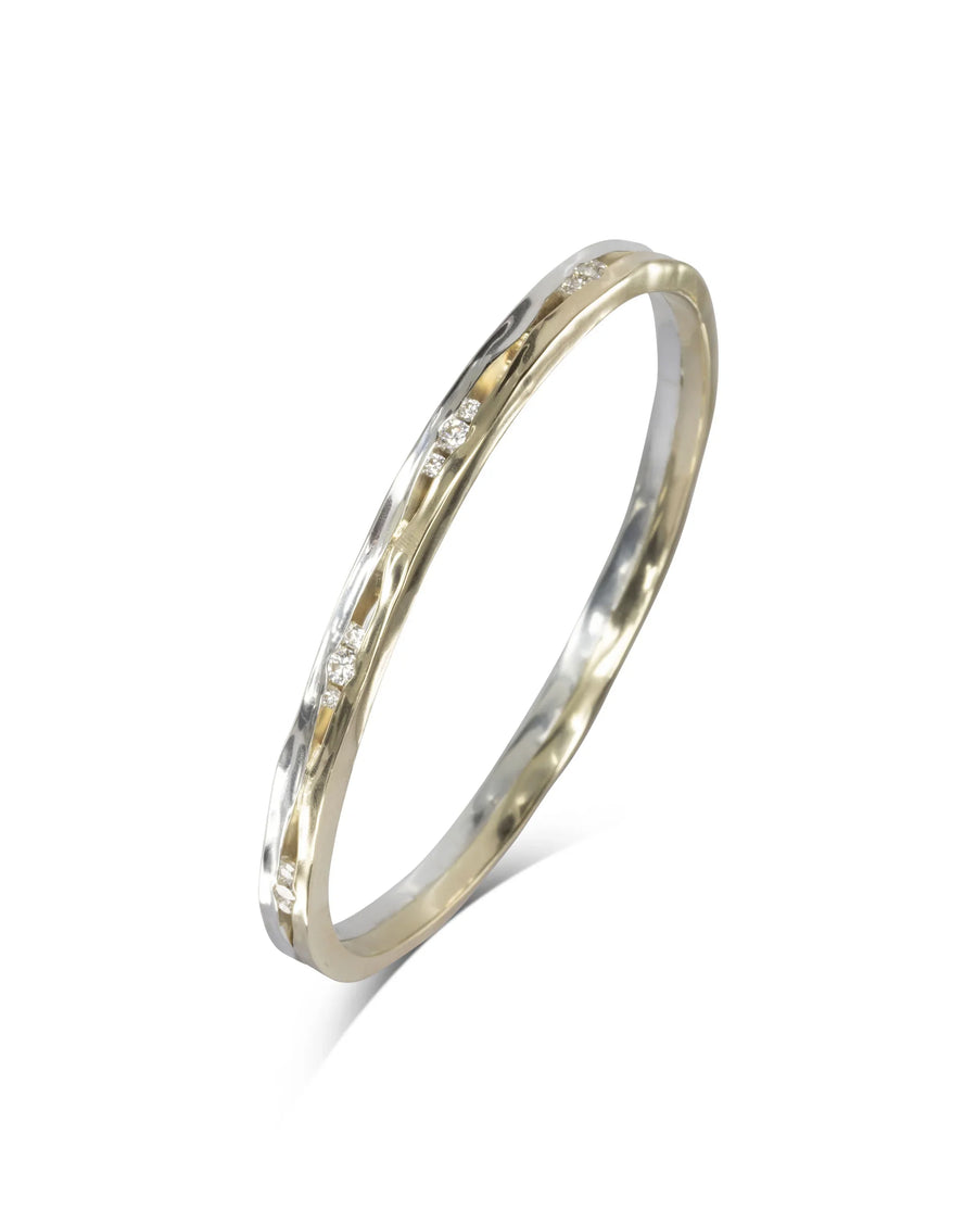 Handcrafted mixed metal bangle with diamonds and organic hammered texture on white background