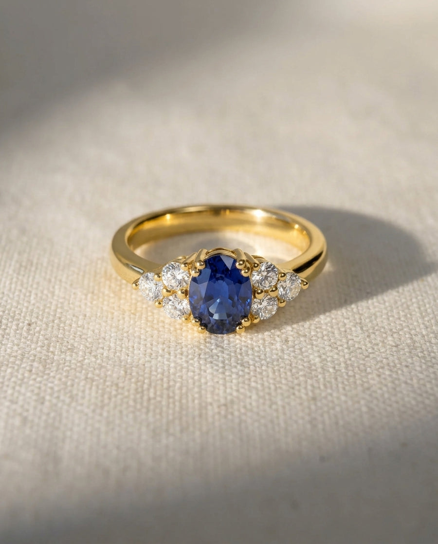 18ct yellow gold ring with an oval sapphire and six round diamonds.