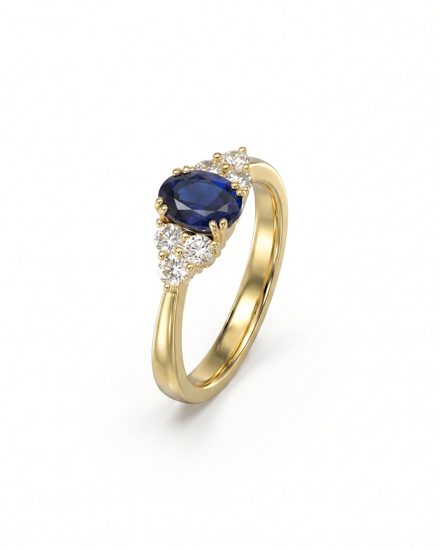 Gold engagement ring with an oval sapphire and six round diamonds.