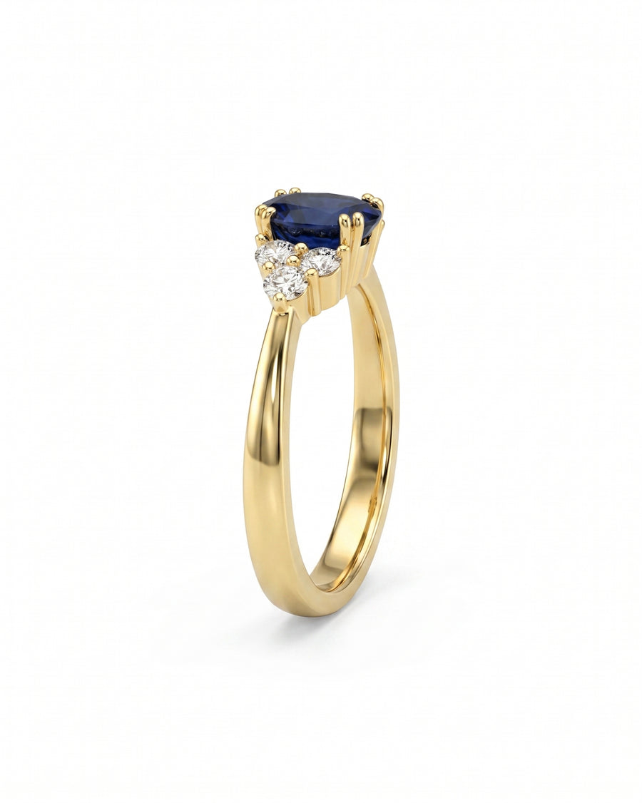 Yellow gold engagement ring with an oval sapphire and three round diamonds.