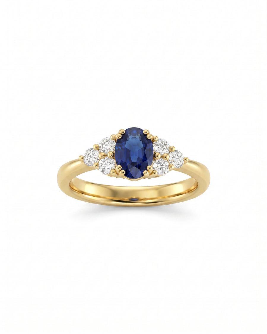 Gold engagement ring with an oval sapphire and six round diamonds.