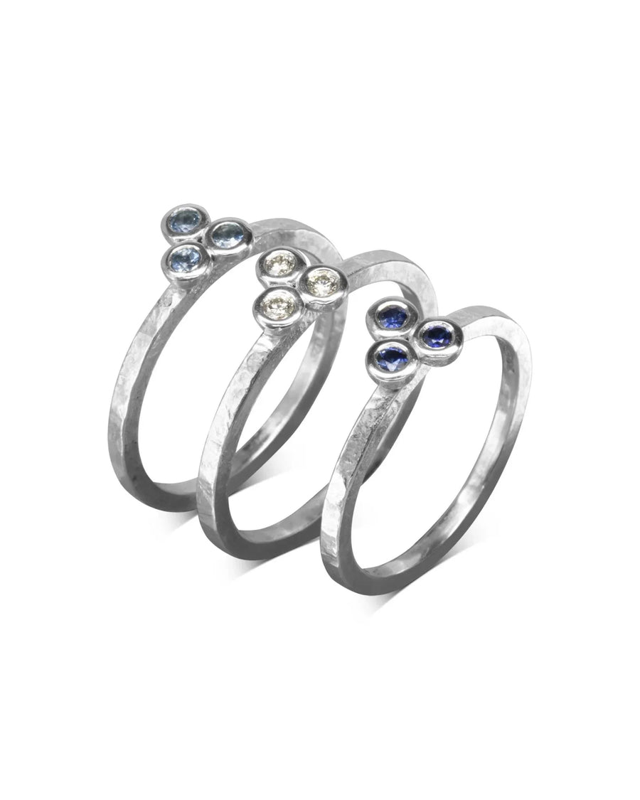 Three hammered gold stackable rings with trefoil gemstone diamonds.