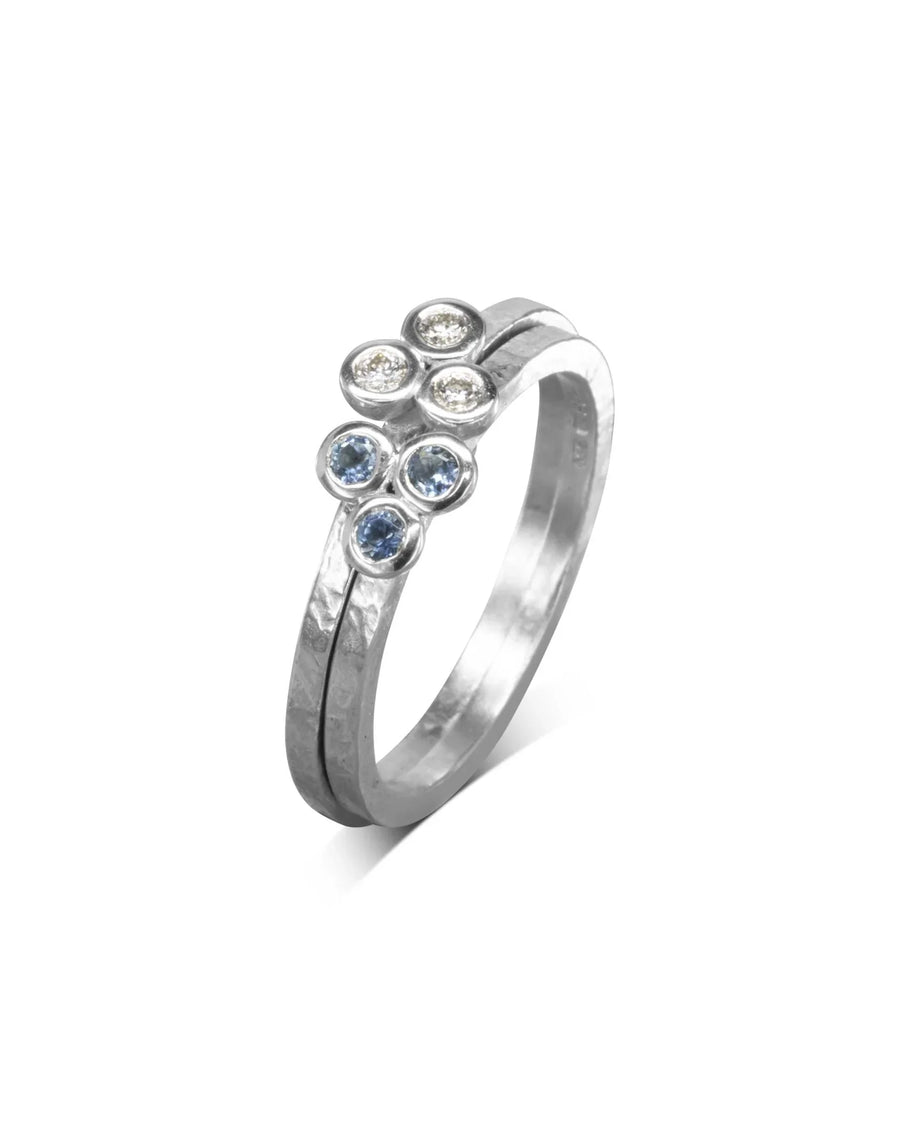 Silver stackable ring with blue and clear gemstone clusters.