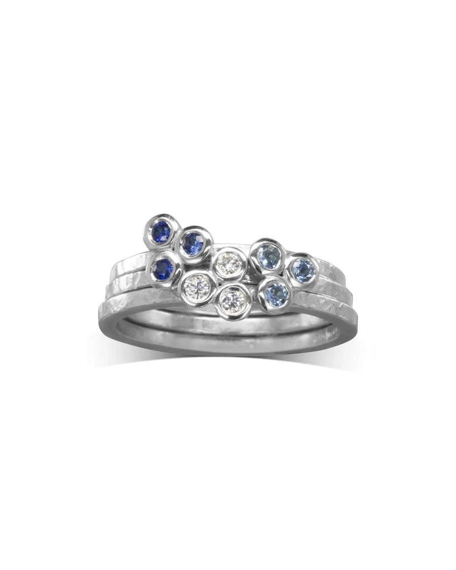 Stackable gold rings with blue sapphires and diamonds.