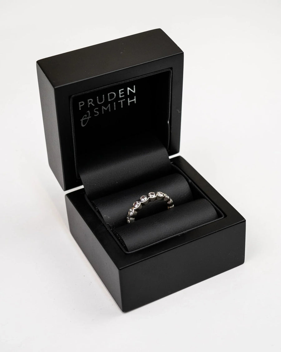Platinum full eternity ring with diamonds in a black box.