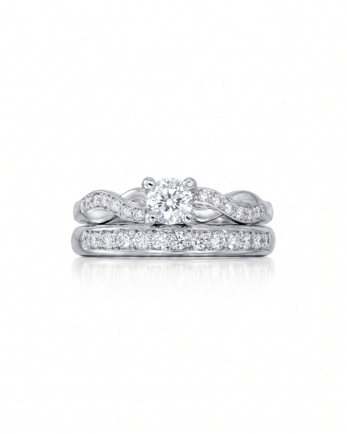 Silver twist engagement ring and wedding band set with round diamonds on a white background.