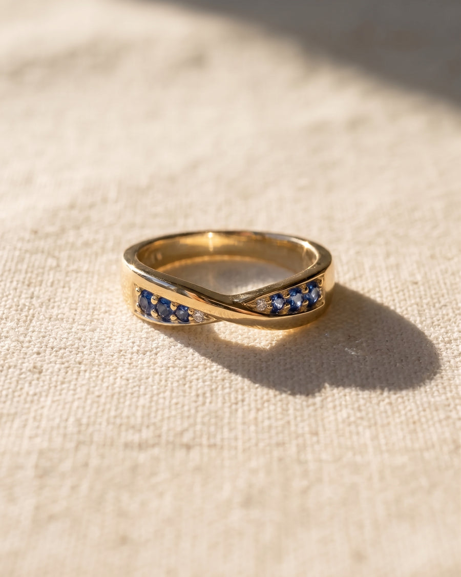 9ct yellow gold twist ring with blue sapphires and small diamonds.
