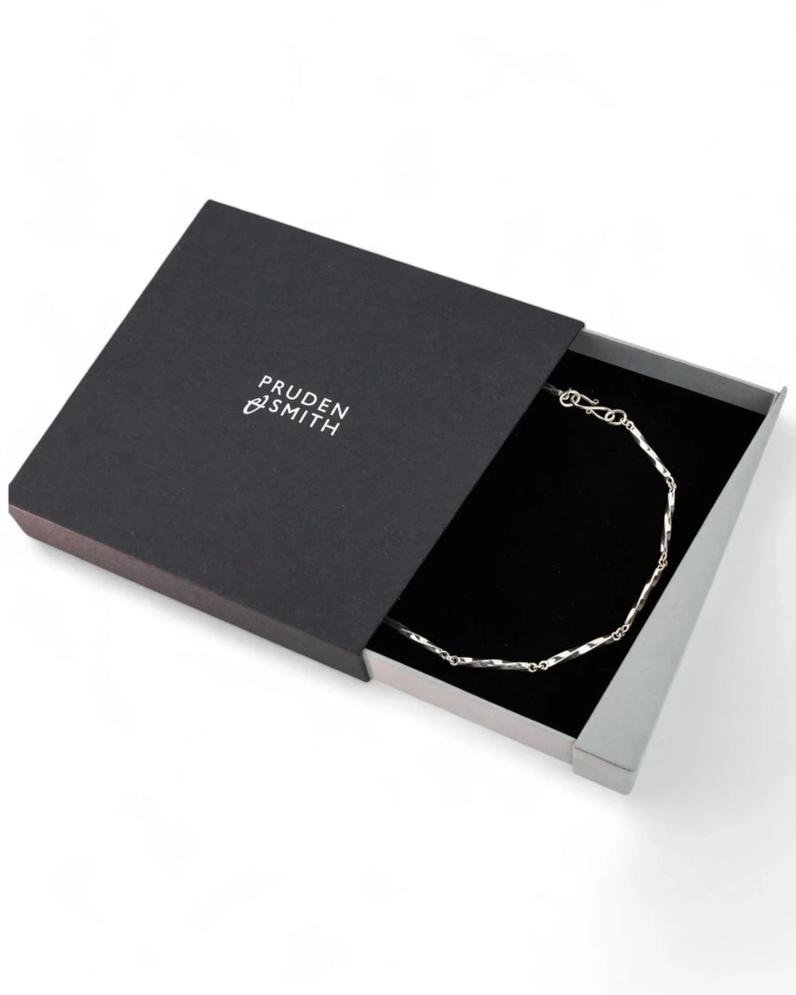 Twisted silver chain necklace displayed in a sleek black jewellery box