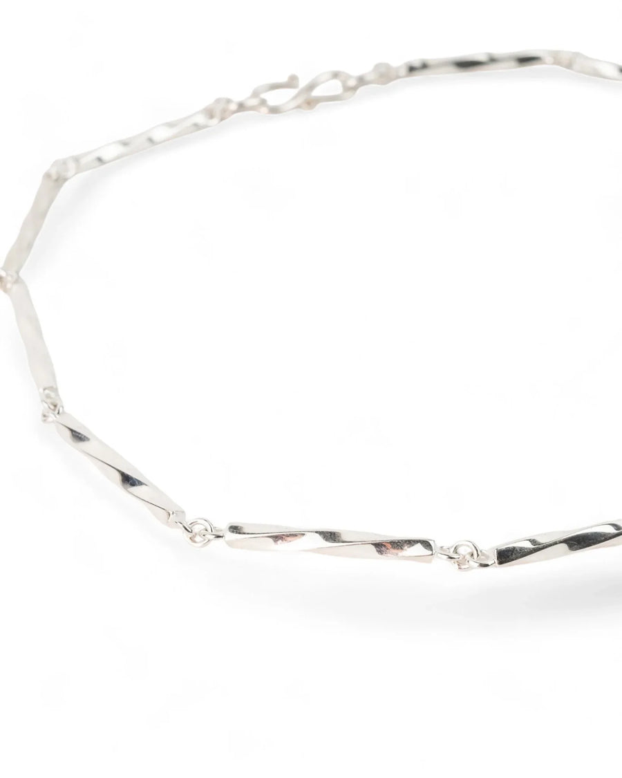 Handmade twisted silver chain necklace with elongated links on white background