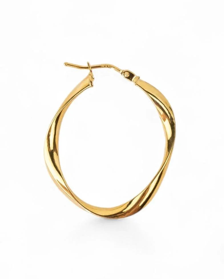 Uneven twisted gold hoop earring with organic shape and polished finish on white background