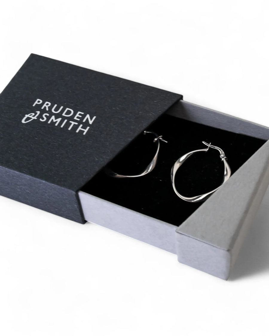 Uneven twisted yellow gold hoop earrings with organic shape in a gift box