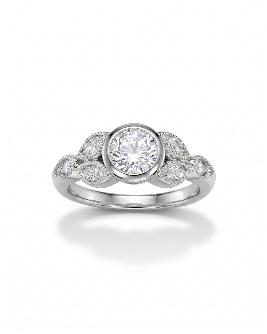 Silver vintage bezel set diamond engagement ring with marquise and round side stones.