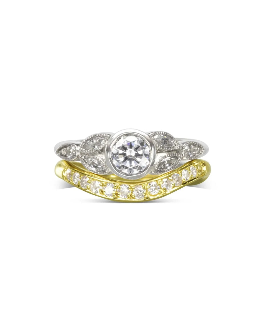 Vintage bezel set diamond engagement ring with a yellow gold diamond band.
